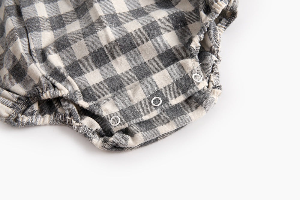 Baby girl long sleeve onesie featuring a plaid pattern and doll collar design in black and grey colors.