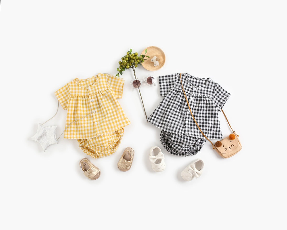 Baby girl wearing a plaid pattern shirt and shorts set in black and yellow, perfect for summer outings.