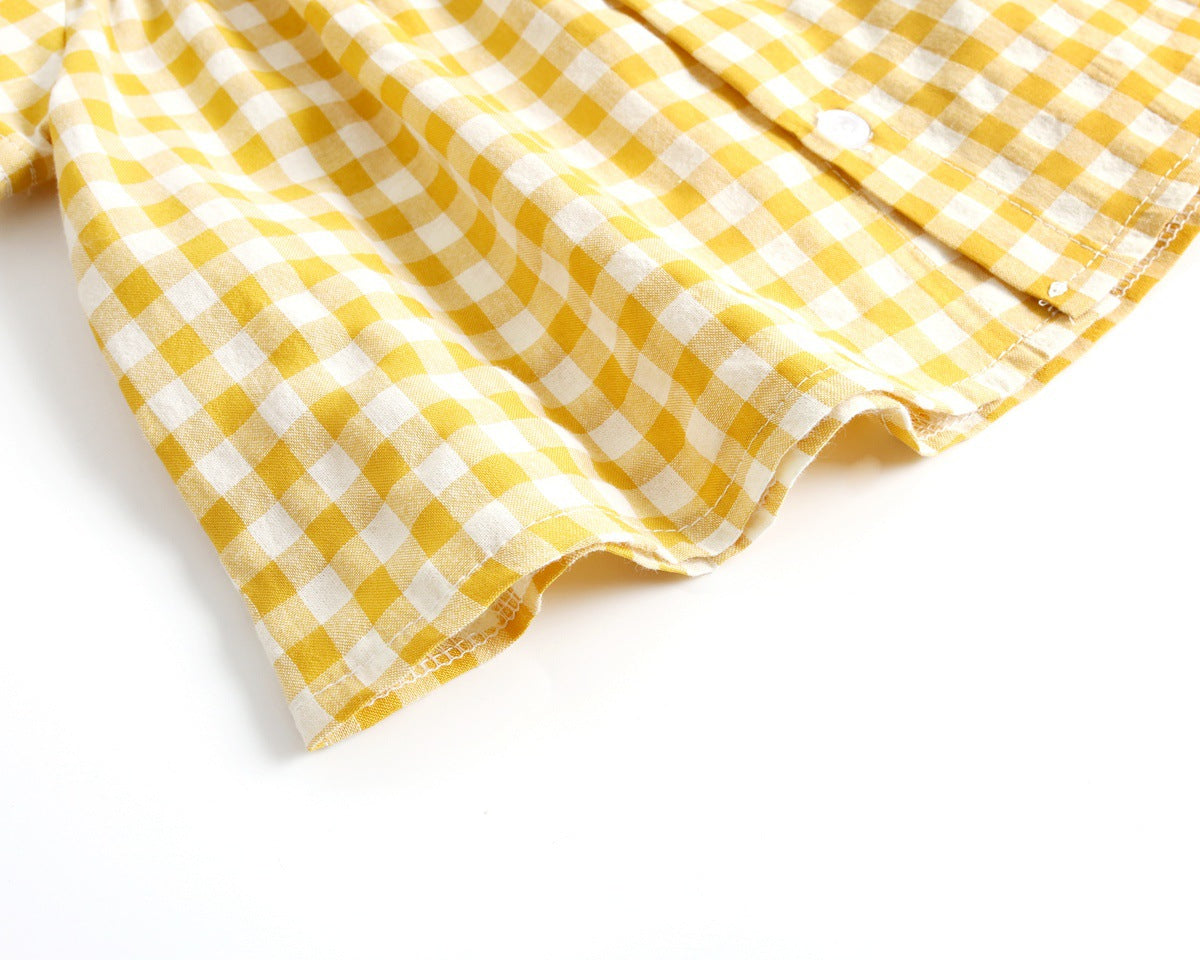 Baby girl wearing a plaid pattern shirt and shorts set in black and yellow, perfect for summer outings.