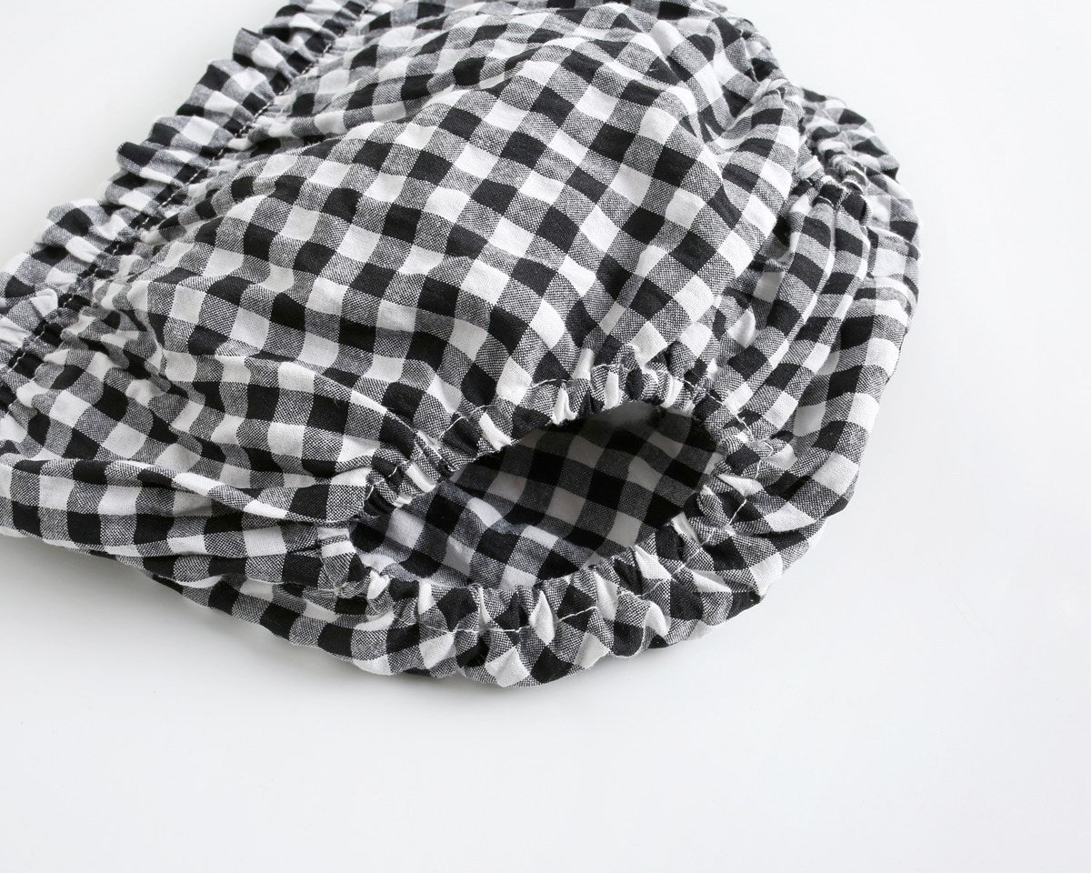 Baby girl wearing a plaid pattern shirt and shorts set in black and yellow, perfect for summer outings.