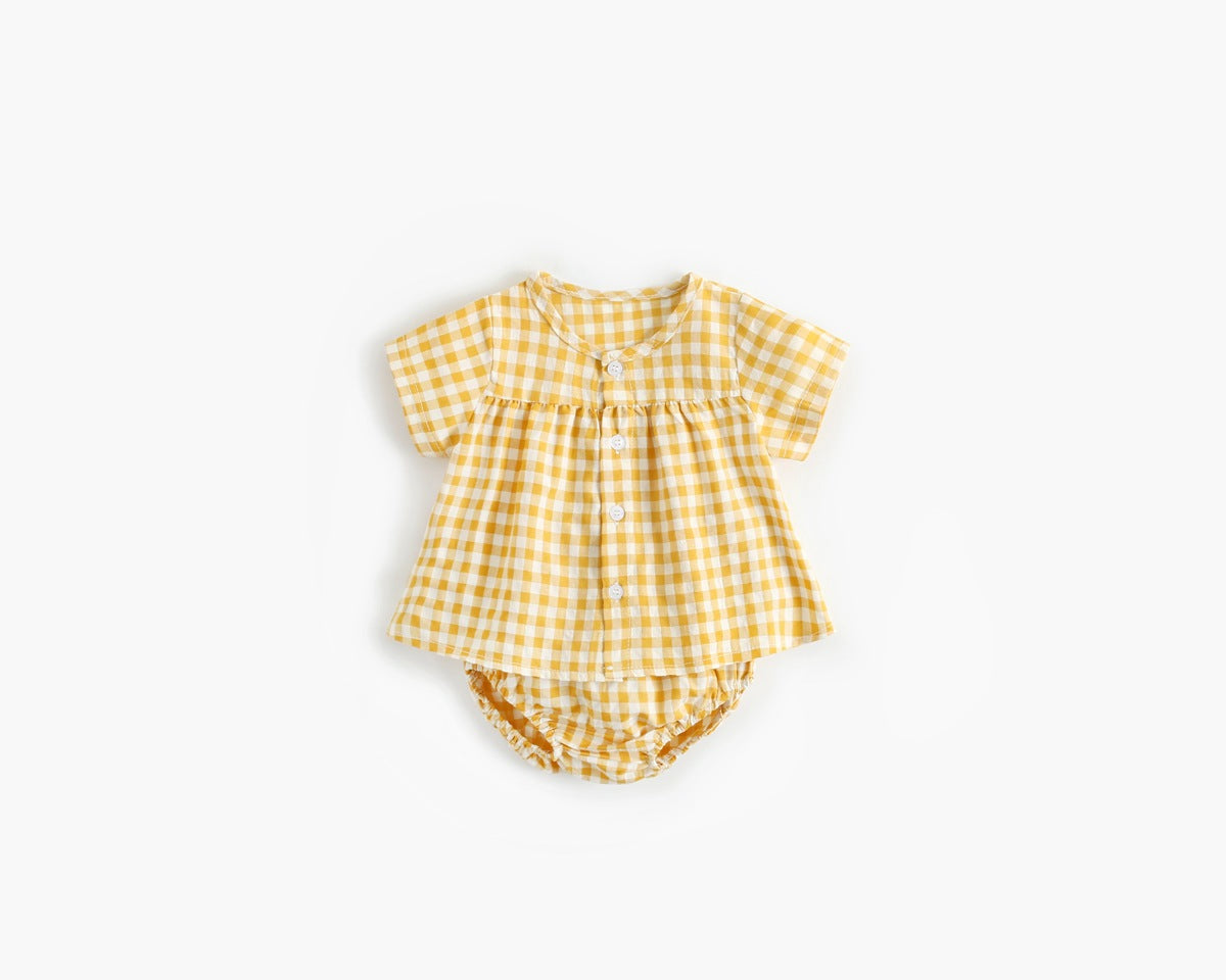 Baby girl wearing a plaid pattern shirt and shorts set in black and yellow, perfect for summer outings.