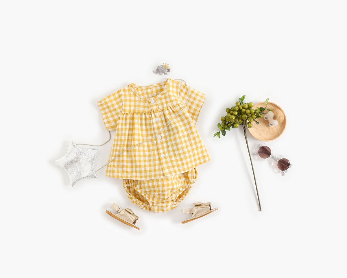 Baby girl wearing a plaid pattern shirt and shorts set in black and yellow, perfect for summer outings.