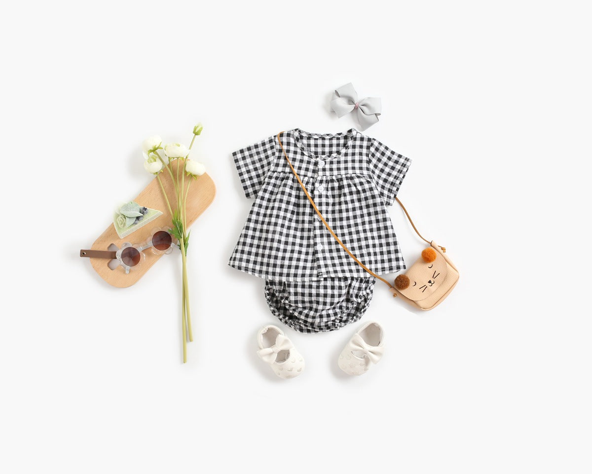 Baby girl wearing a plaid pattern shirt and shorts set in black and yellow, perfect for summer outings.