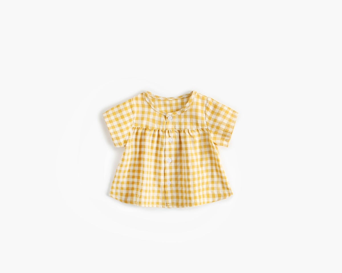 Baby girl wearing a plaid pattern shirt and shorts set in black and yellow, perfect for summer outings.