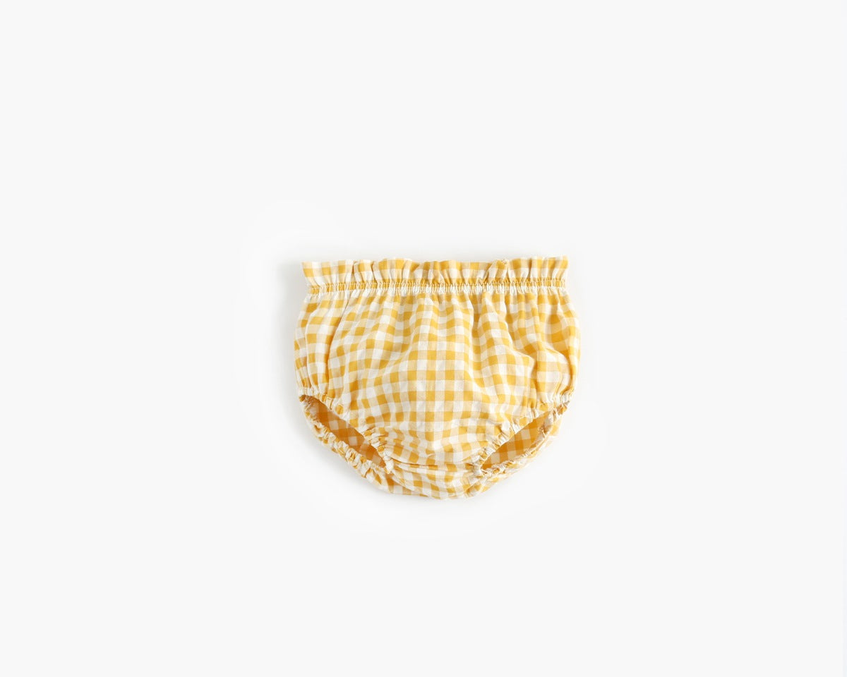 Baby girl wearing a plaid pattern shirt and shorts set in black and yellow, perfect for summer outings.