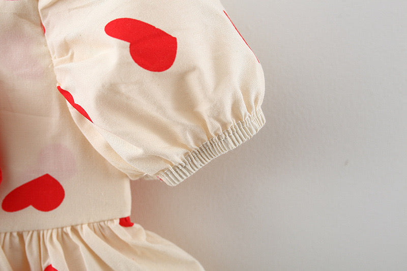 Baby girl wearing a polka dot graphic bow tie princess dress in black with golden accents, showcasing elegance and charm.