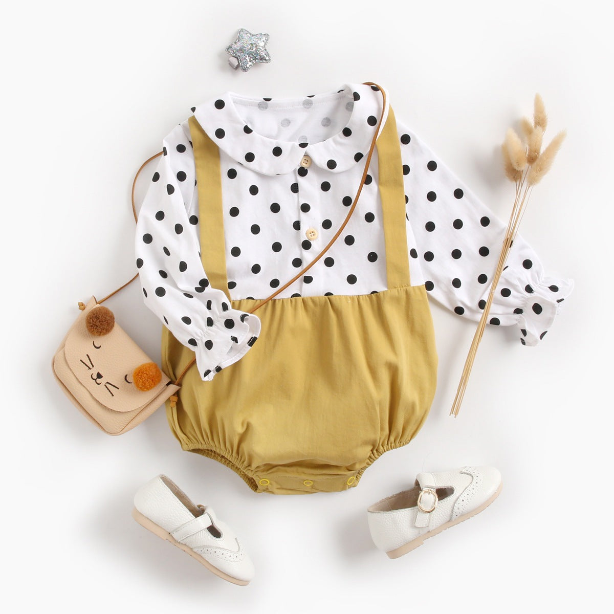 Baby girl wearing a stylish yellow polka dot onesie with a doll collar design and backless long sleeves.