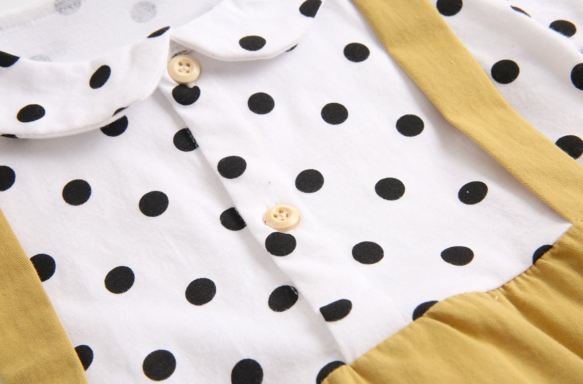 Baby girl wearing a stylish yellow polka dot onesie with a doll collar design and backless long sleeves.
