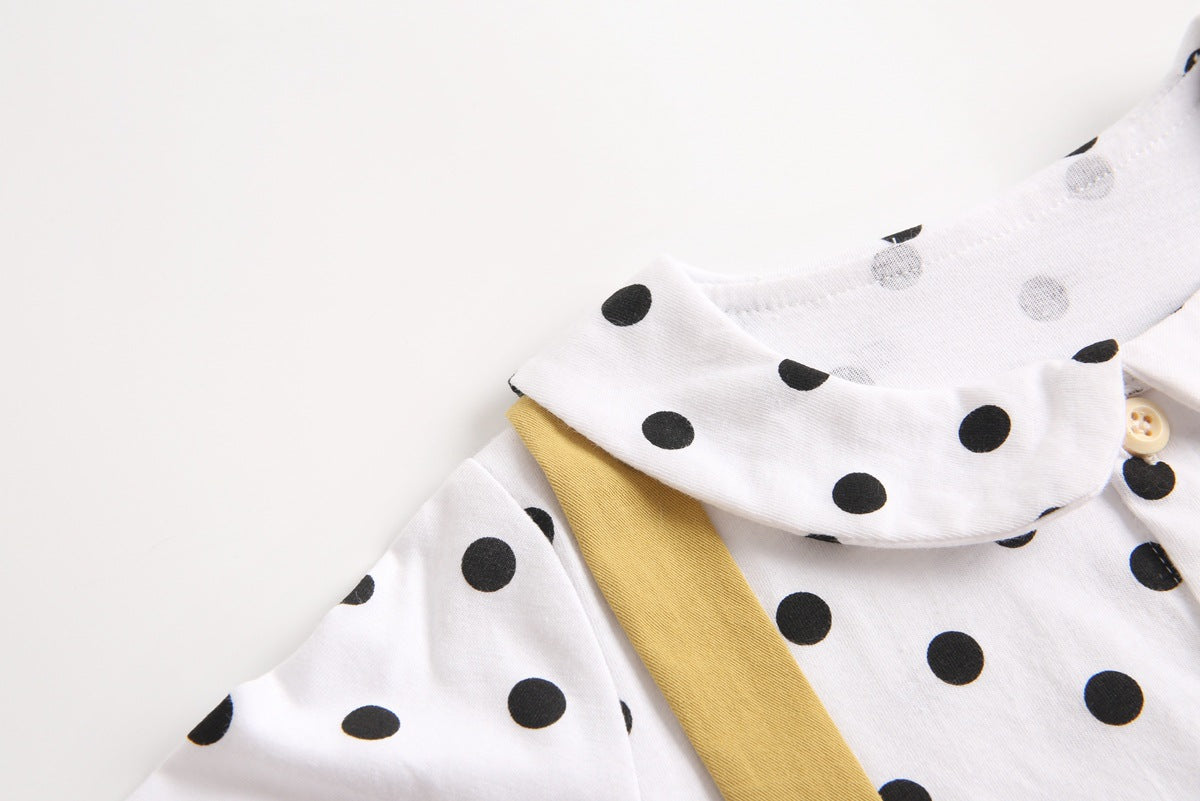 Baby girl wearing a stylish yellow polka dot onesie with a doll collar design and backless long sleeves.