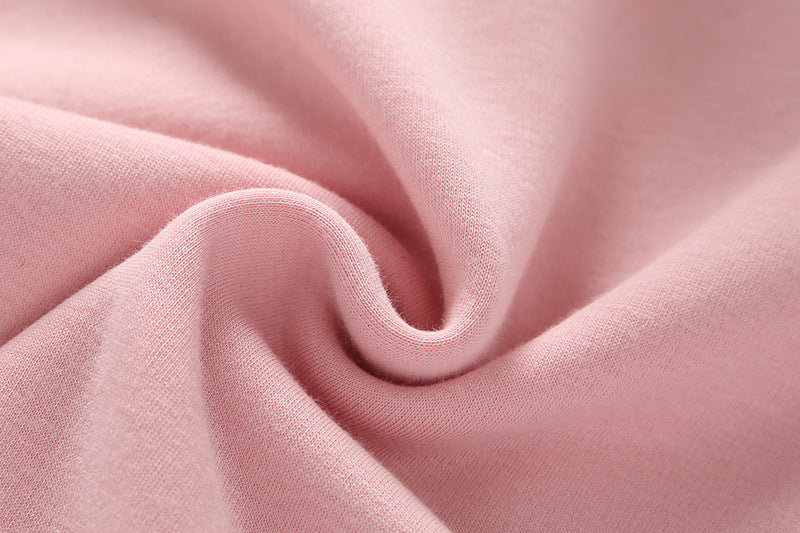 Baby girl wearing a cute rabbit ear design long sleeved onesie in pink, showcasing a playful print pattern.