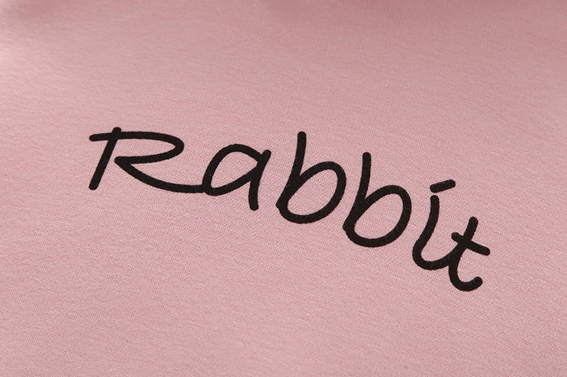 Baby girl wearing a cute rabbit ear design long sleeved onesie in pink, showcasing a playful print pattern.