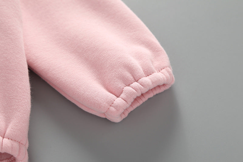 Baby girl wearing a cute rabbit ear design long sleeved onesie in pink, showcasing a playful print pattern.