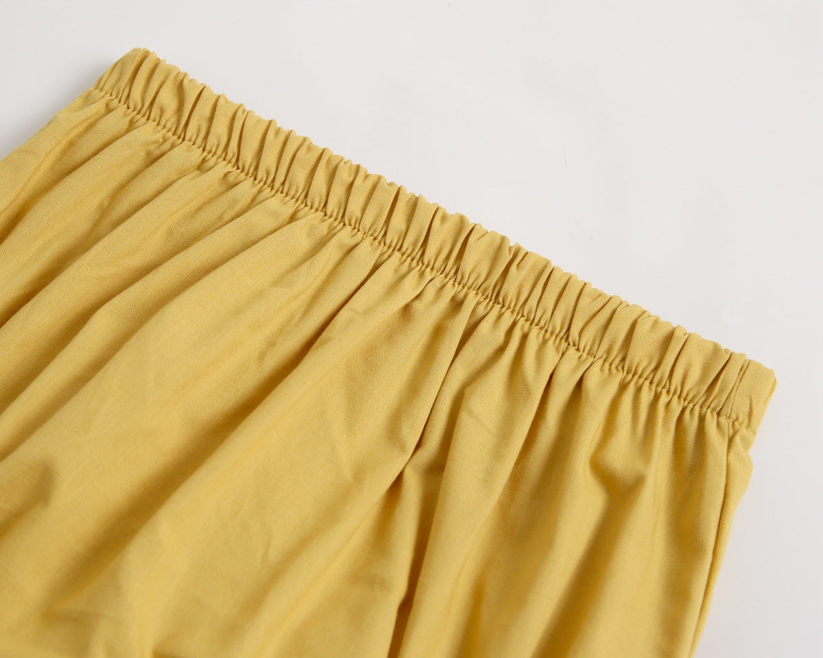 Adorable baby girl outfit featuring a ruffle sleeveless top and matching shorts with a heart printed pattern in pink and yellow.