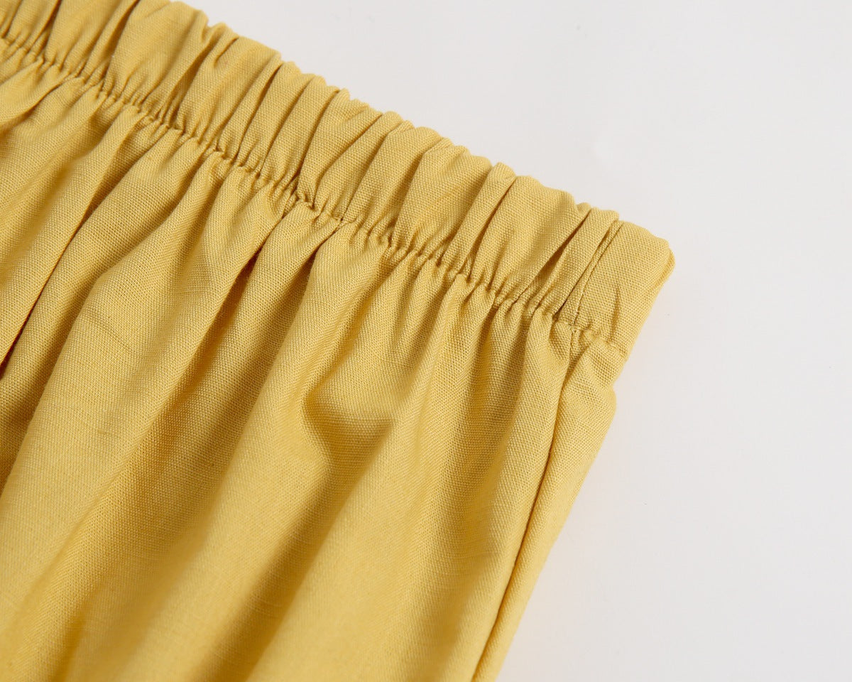 Adorable baby girl outfit featuring a ruffle sleeveless top and matching shorts with a heart printed pattern in pink and yellow.