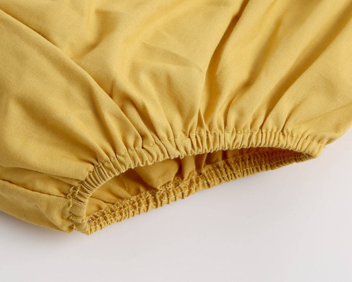 Adorable baby girl outfit featuring a ruffle sleeveless top and matching shorts with a heart printed pattern in pink and yellow.