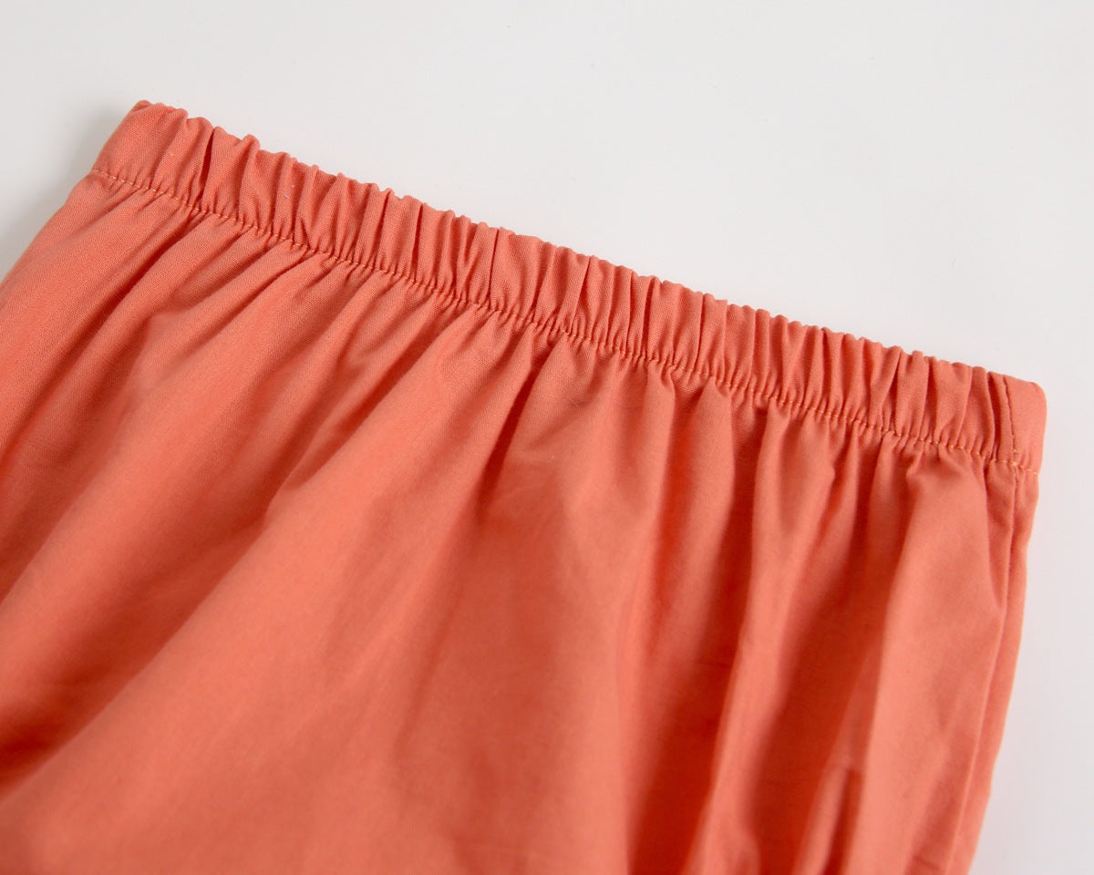 Adorable baby girl outfit featuring a ruffle sleeveless top and matching shorts with a heart printed pattern in pink and yellow.