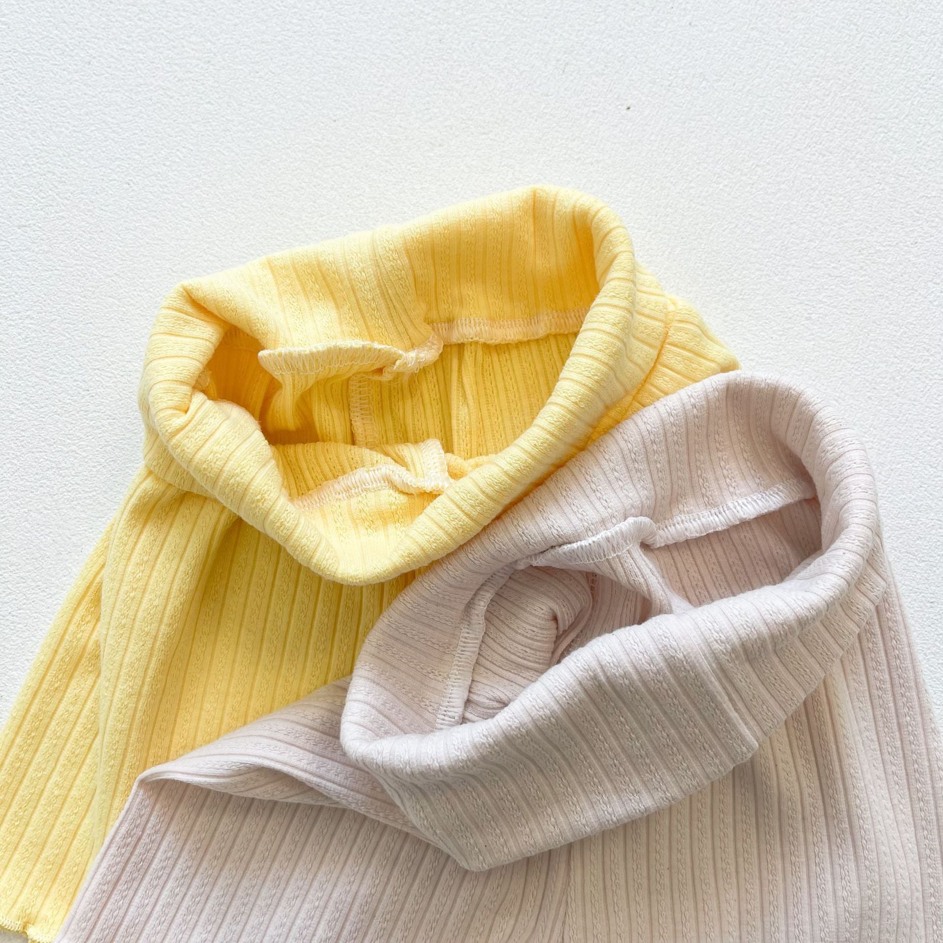 Baby girl wearing a ribbed knit sling top and shorts set with lettuce trim in yellow and apricot colors, perfect for summer.