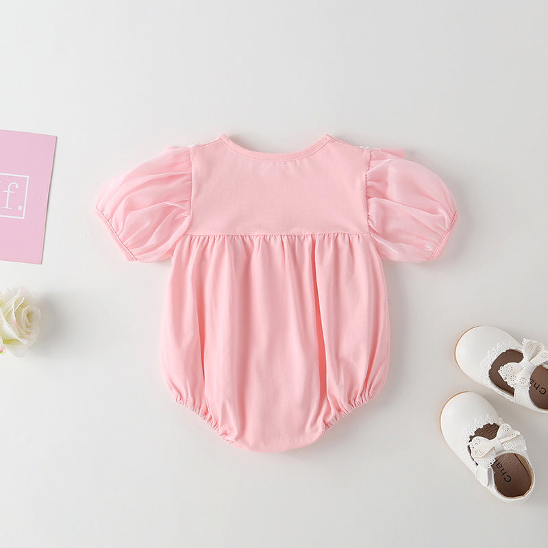 Adorable baby girl onesie featuring a round collar, short sleeves, and a small daisy pattern in pink cotton fabric.
