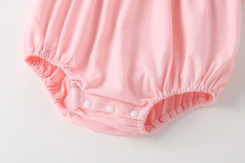 Adorable baby girl onesie featuring a round collar, short sleeves, and a small daisy pattern in pink cotton fabric.