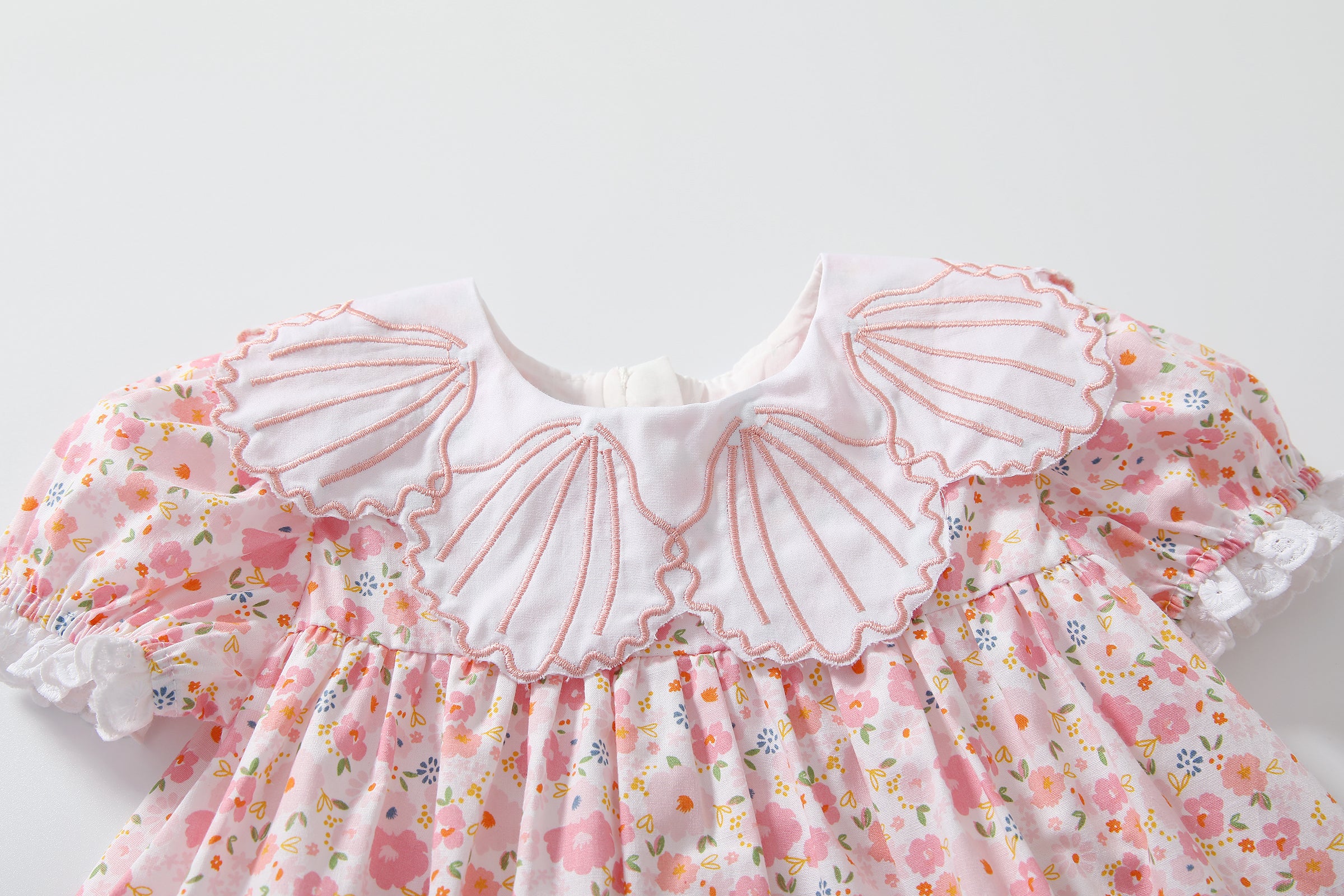 Baby girl dress featuring a floral print and shell shape collar, perfect for summer occasions.