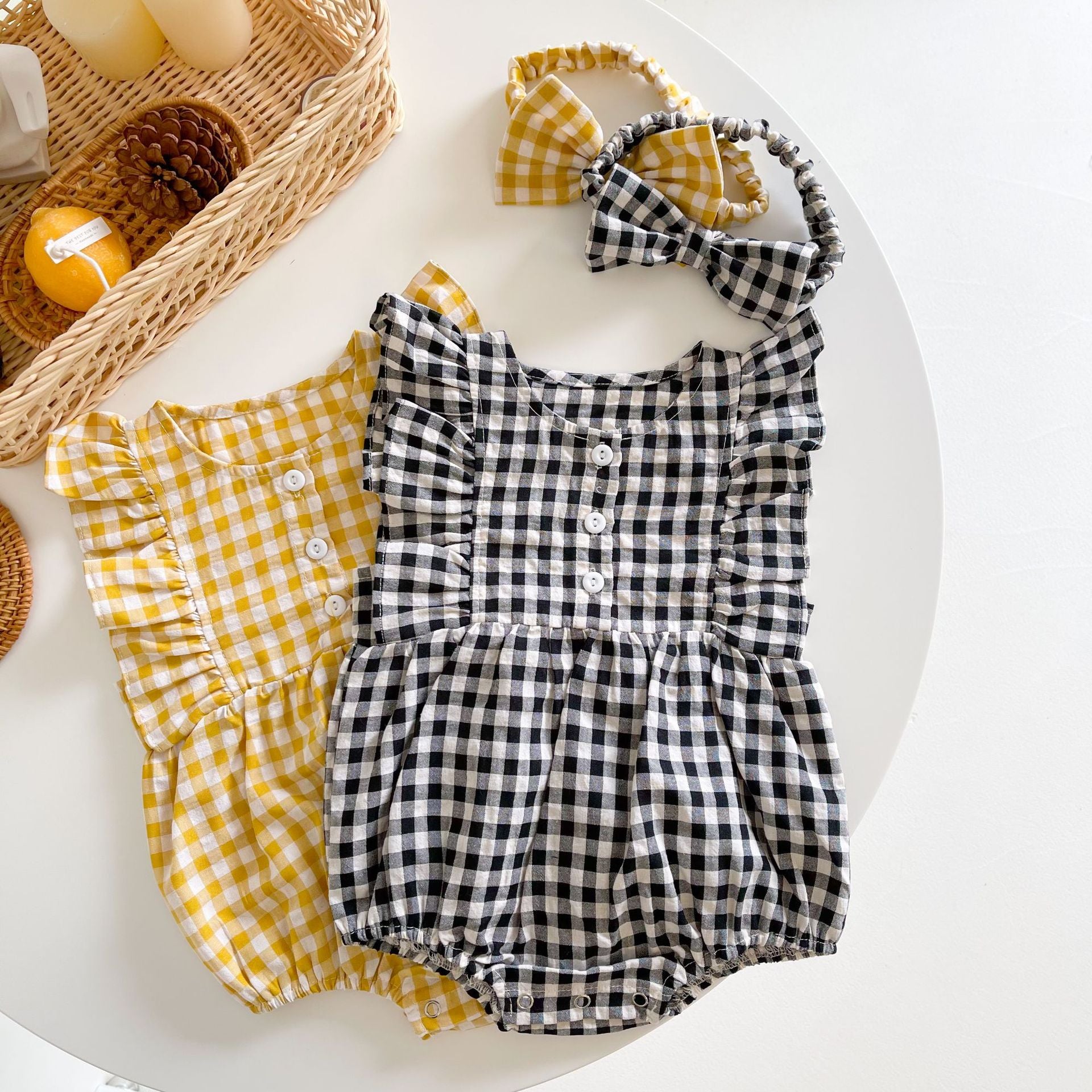 Baby girl sleeveless onesie featuring a stylish grid pattern in black and yellow, perfect for summer wear.