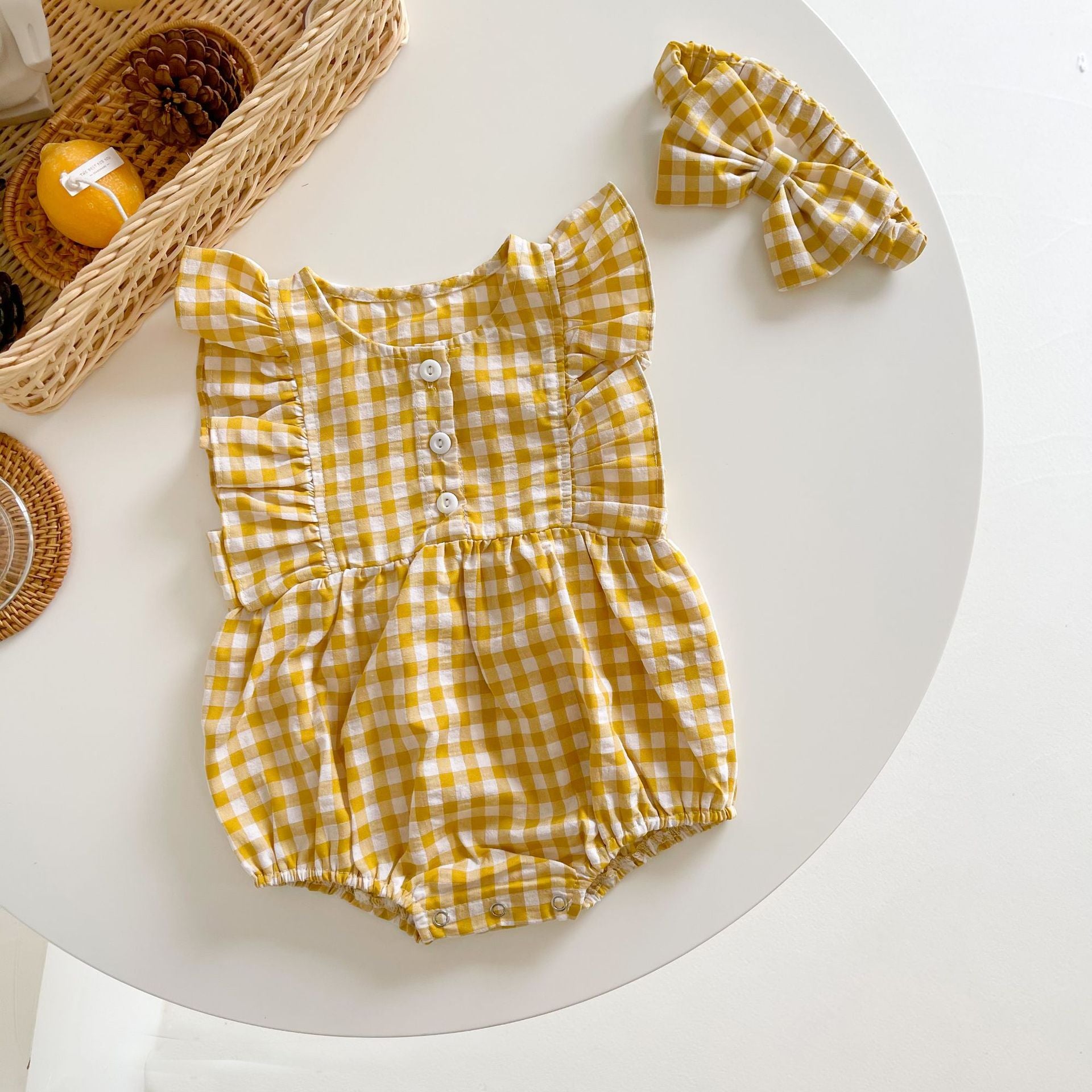 Baby girl sleeveless onesie featuring a stylish grid pattern in black and yellow, perfect for summer wear.