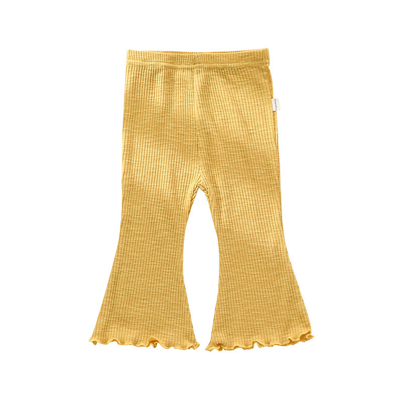Adorable baby girl wearing solid color autumn bell-bottomed pants in various colors, showcasing the stylish design and comfortable fit.