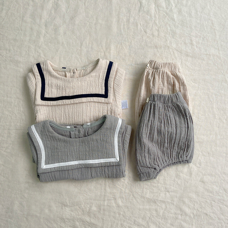 Baby girl wearing a solid color big lapel shirt and sailor shorts combo in grey and apricot, perfect for summer outings.