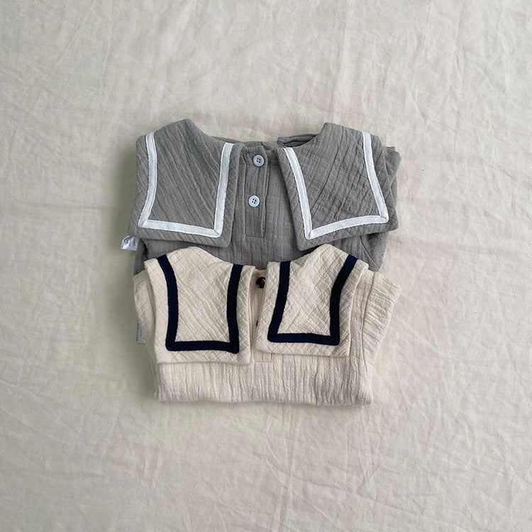 Baby girl wearing a solid color big lapel shirt and sailor shorts combo in grey and apricot, perfect for summer outings.