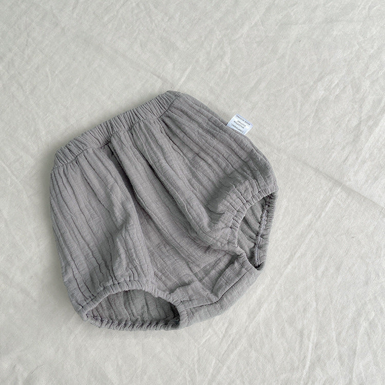 Baby girl wearing a solid color big lapel shirt and sailor shorts combo in grey and apricot, perfect for summer outings.