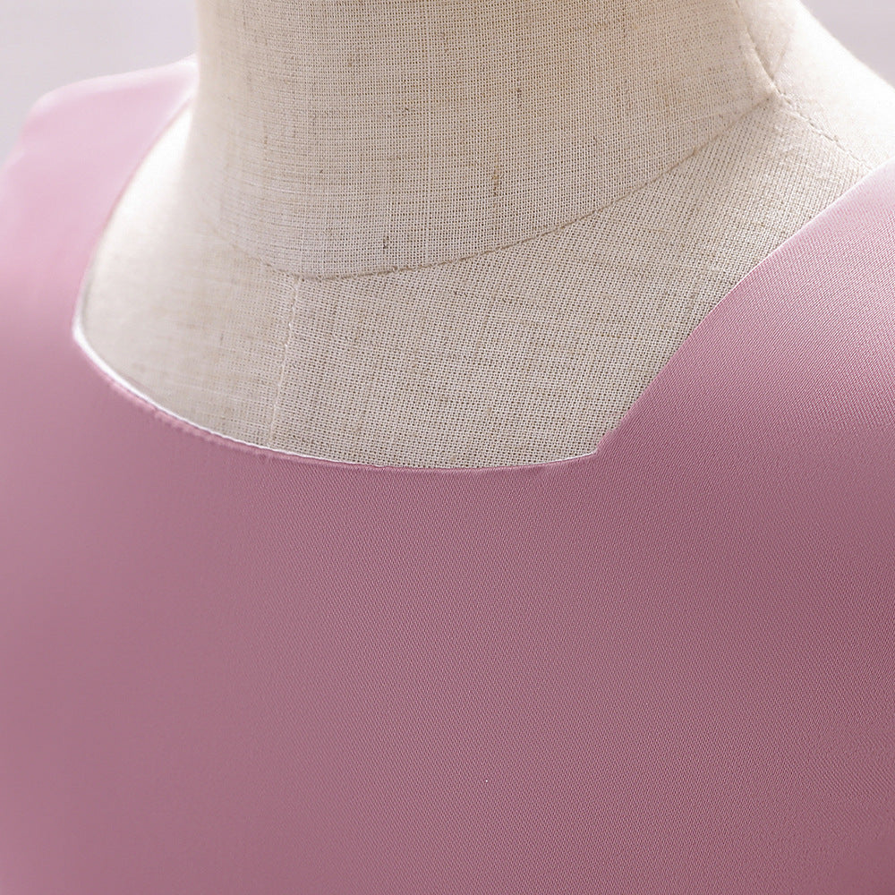 A cute baby girl wearing a solid color sleeveless dress with a bow patch, showcasing vibrant colors and a stylish design.