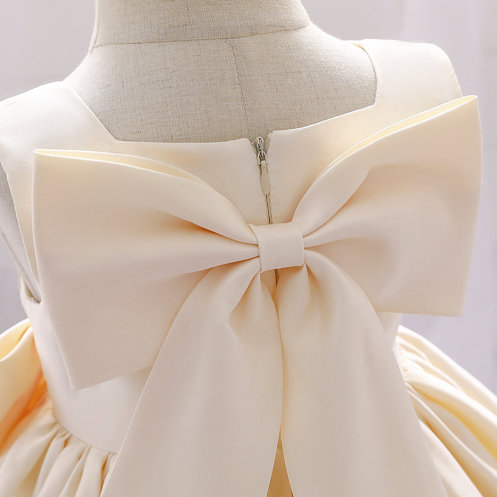 A cute baby girl wearing a solid color sleeveless dress with a bow patch, showcasing vibrant colors and a stylish design.