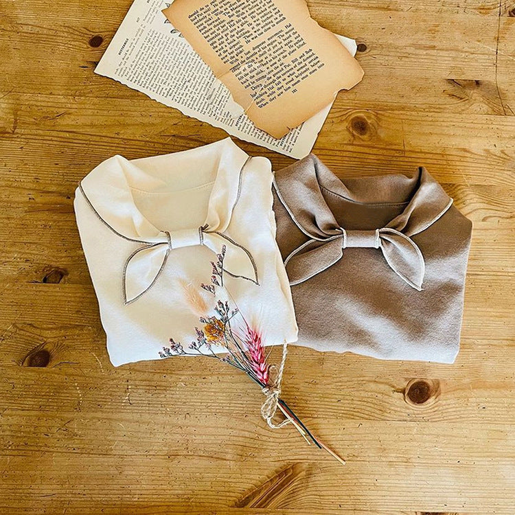 Baby girl long sleeve pullover top with solid color and bow tie design, available in white and coffee, made from soft cotton material.