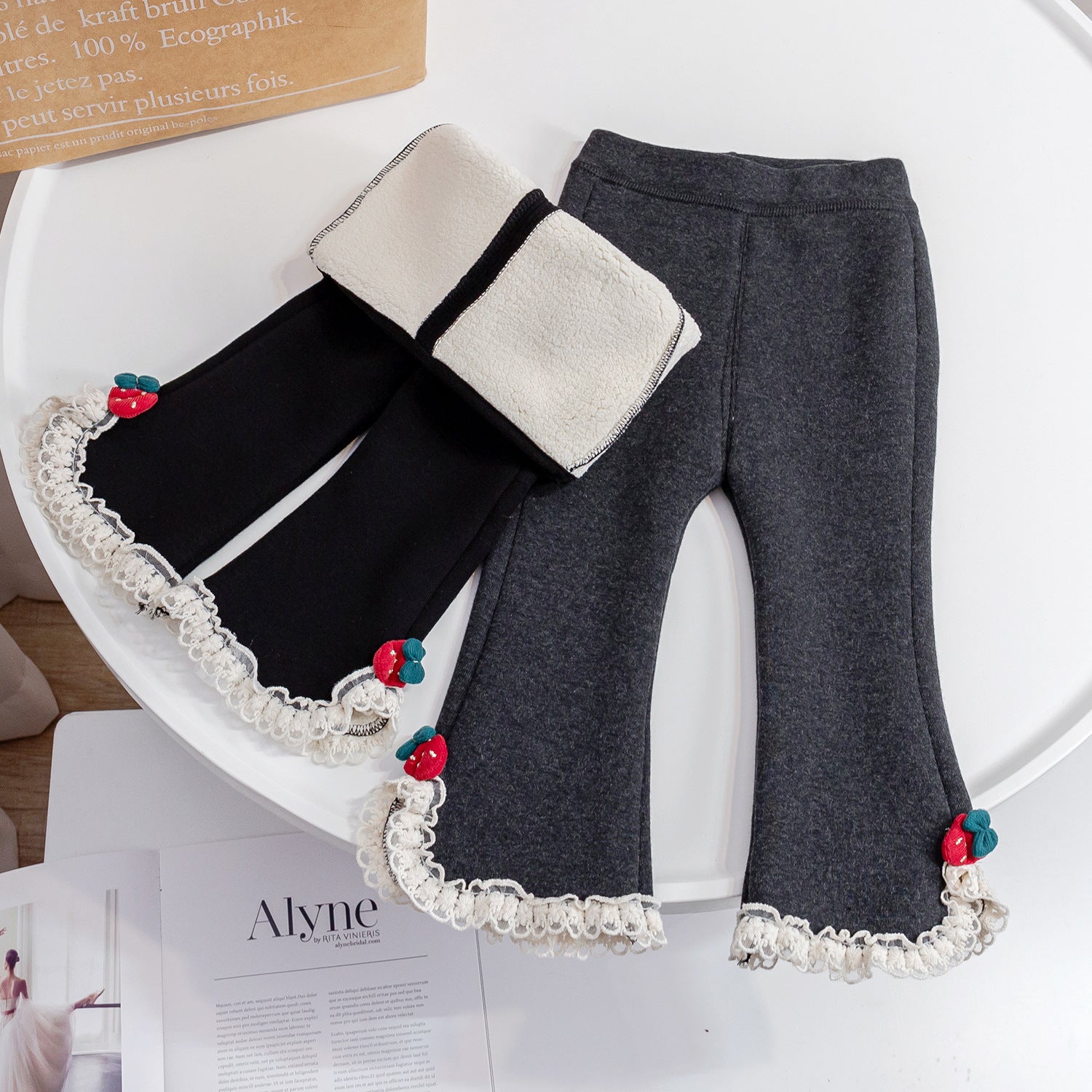 Baby girl fleece pants in solid color with mesh patches, available in black and grey, designed for warmth and comfort.