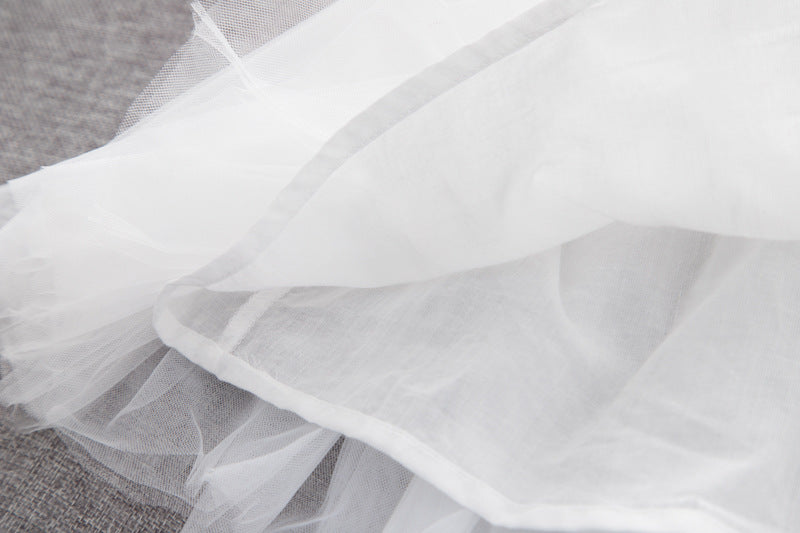 A stylish baby girl dress featuring a solid color mesh patchwork design, perfect for summer wear, available in white and pink.