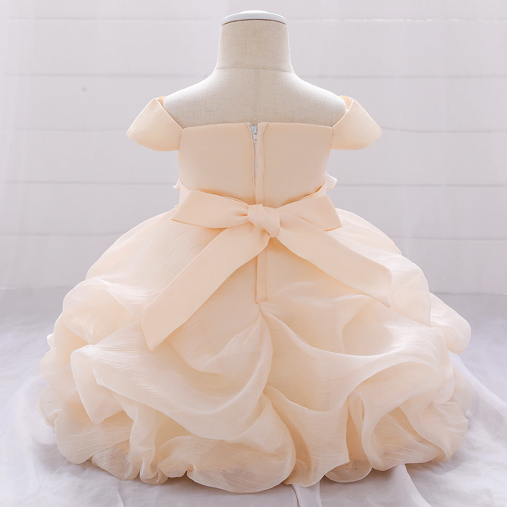 Baby girl wearing a solid color one shoulder tutu dress in white, perfect for formal occasions like baptisms.