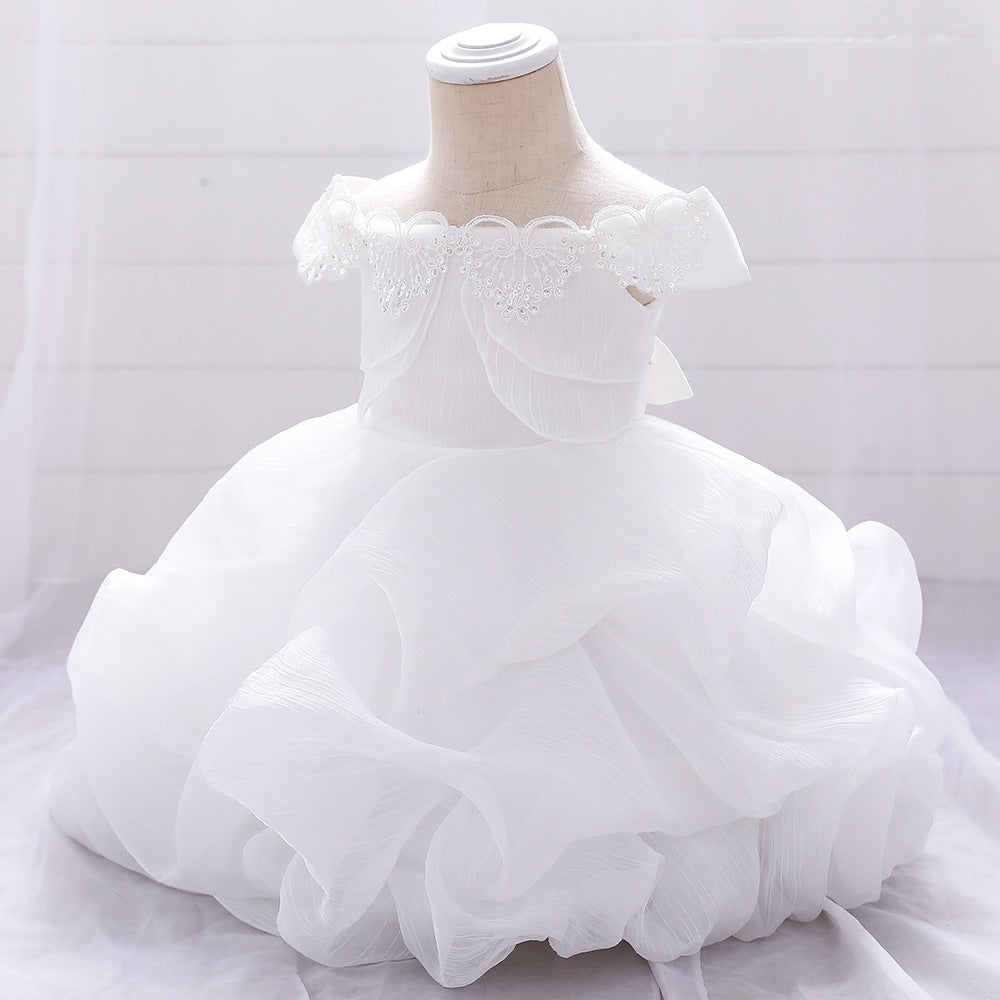 Baby girl wearing a solid color one shoulder tutu dress in white, perfect for formal occasions like baptisms.