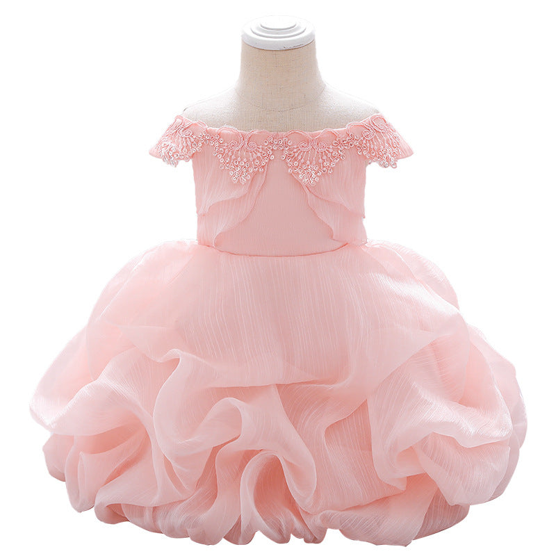 Baby girl wearing a solid color one shoulder tutu dress in white, perfect for formal occasions like baptisms.