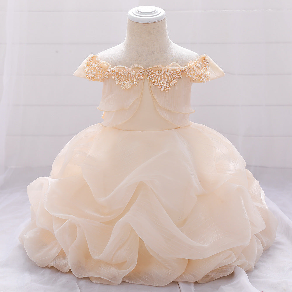 Baby girl wearing a solid color one shoulder tutu dress in white, perfect for formal occasions like baptisms.