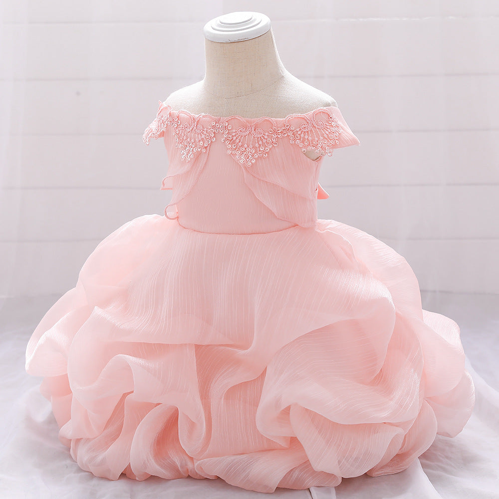 Baby girl wearing a solid color one shoulder tutu dress in white, perfect for formal occasions like baptisms.