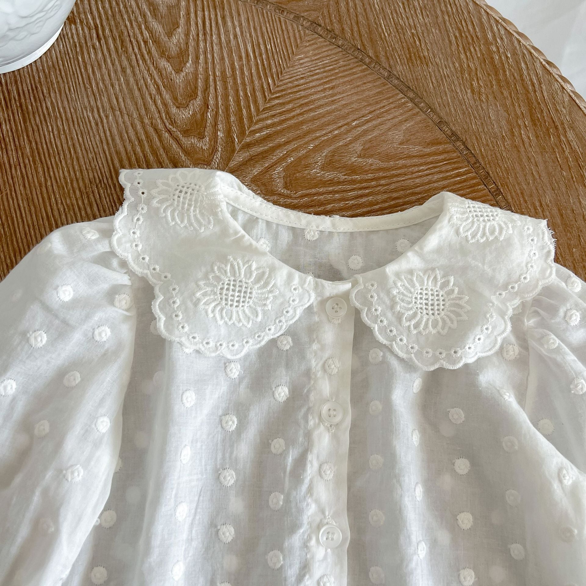 Baby girl wearing a solid color doll neck shirt and shorts set in white and green, showcasing a stylish and comfortable outfit.