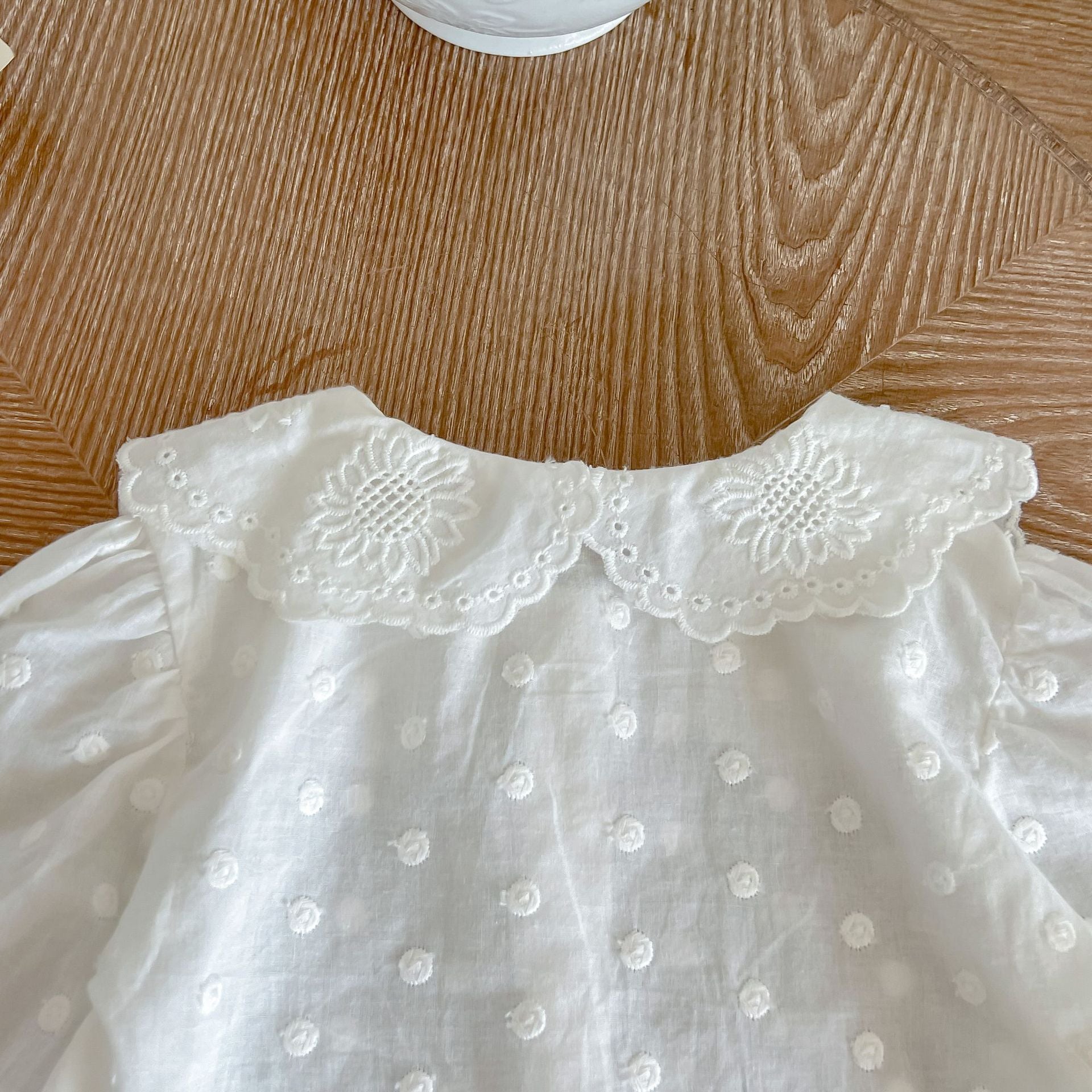 Baby girl wearing a solid color doll neck shirt and shorts set in white and green, showcasing a stylish and comfortable outfit.