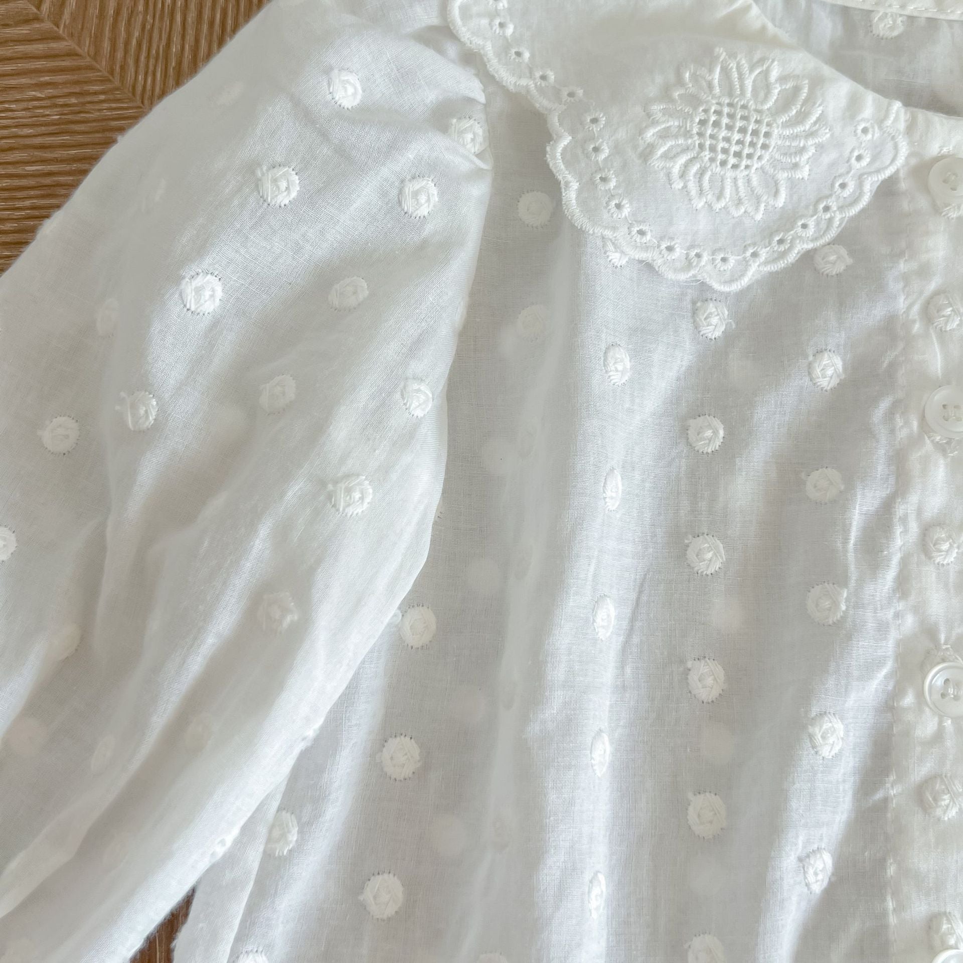 Baby girl wearing a solid color doll neck shirt and shorts set in white and green, showcasing a stylish and comfortable outfit.