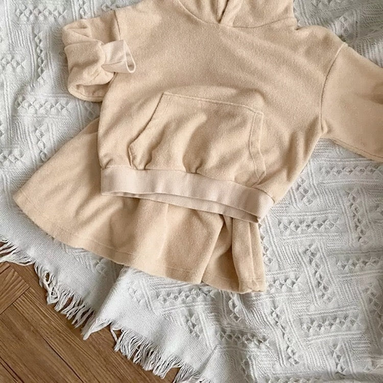 Baby girl wearing a soft cotton hoodie and skirt set in green, showcasing comfort and style.