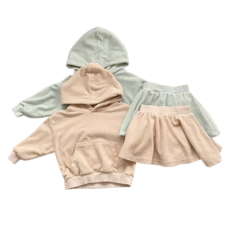 Baby girl wearing a soft cotton hoodie and skirt set in green, showcasing comfort and style.