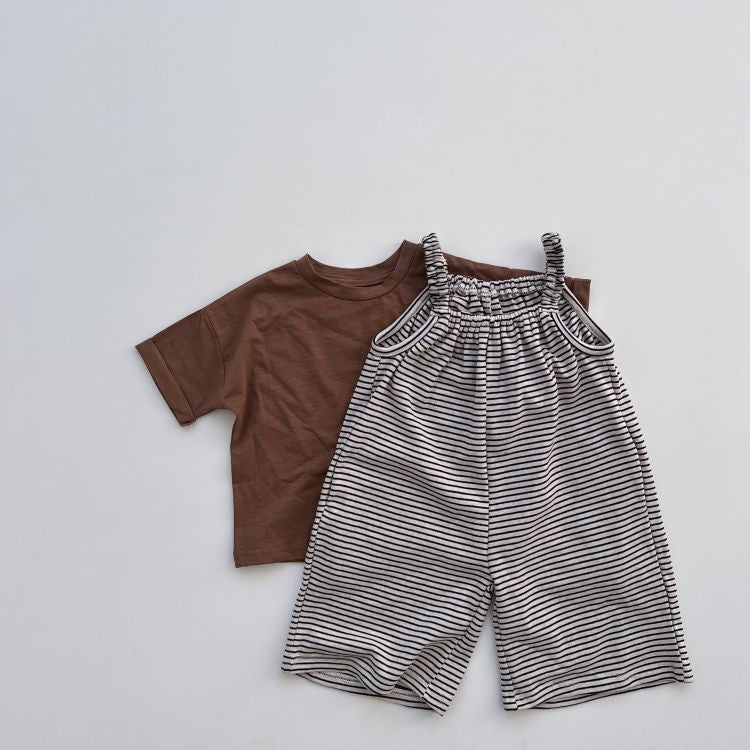 Baby girl wearing a stylish striped sleeveless long-romper in black, perfect for spring and summer.