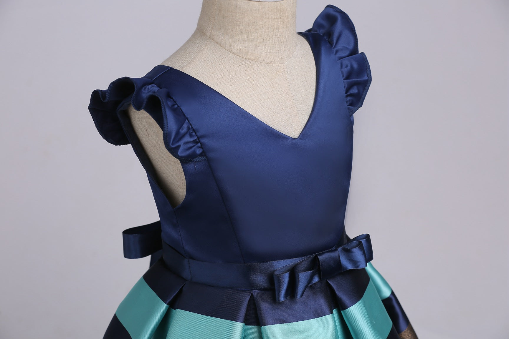 Baby girl wearing a striped pattern V-neck western style formal dress in vibrant colors, perfect for summer occasions.
