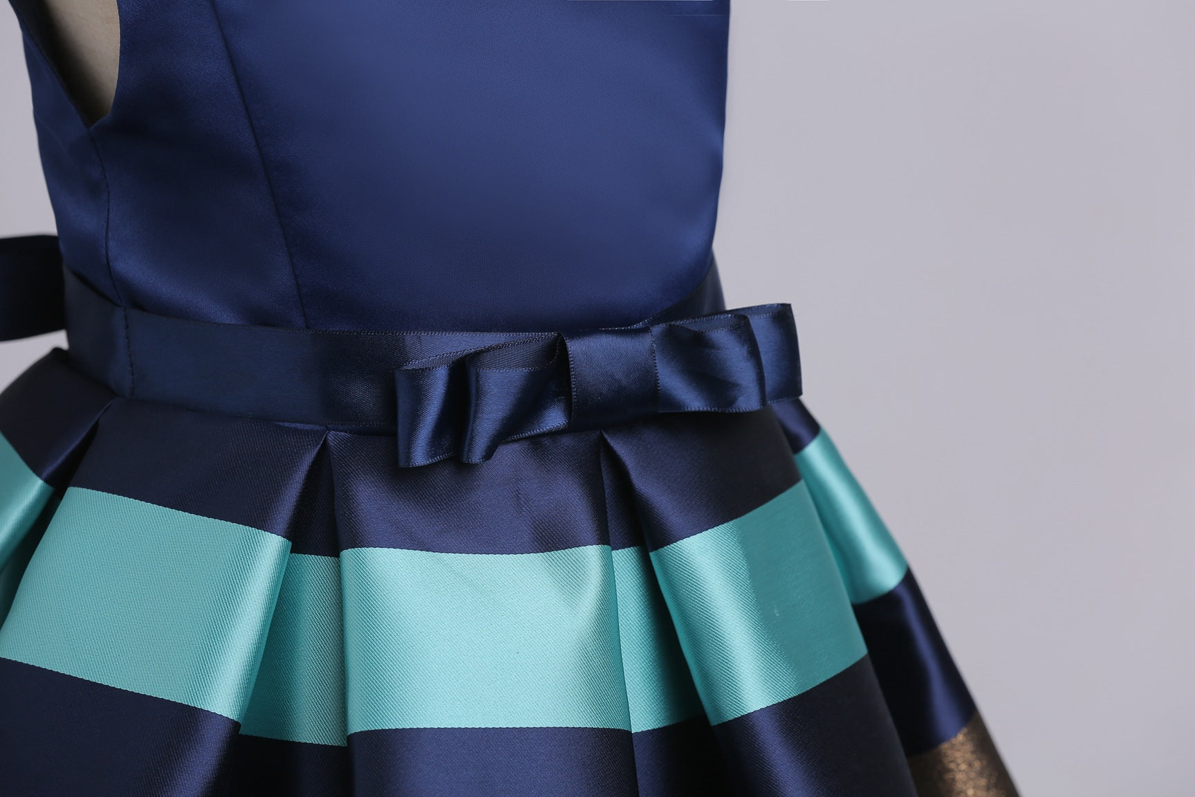 Baby girl wearing a striped pattern V-neck western style formal dress in vibrant colors, perfect for summer occasions.