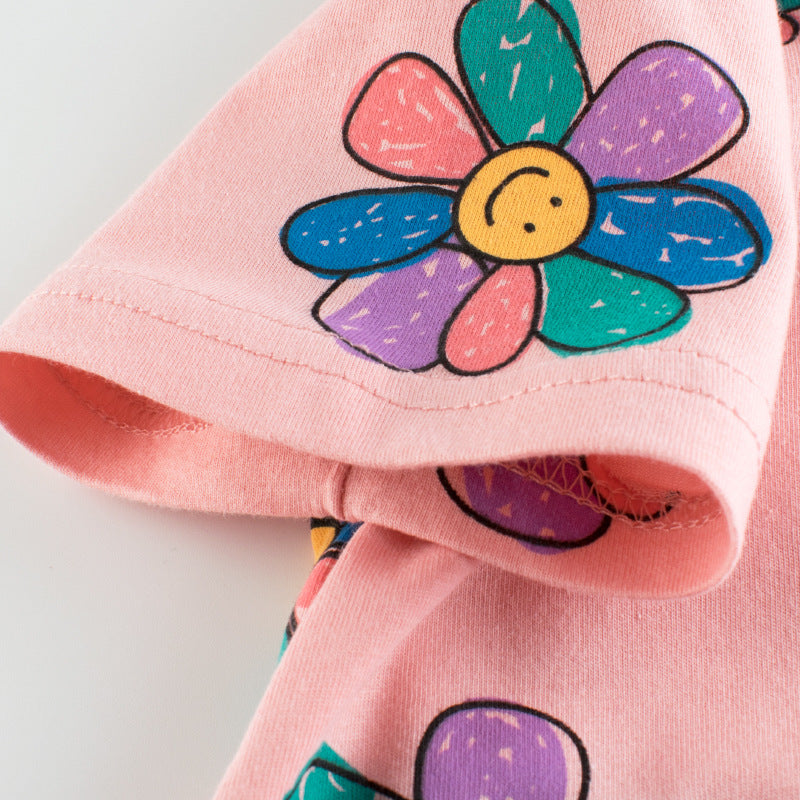 Baby girl wearing a pink sunflower print short sleeved t-shirt, perfect for summer days, showcasing a vibrant floral design.
