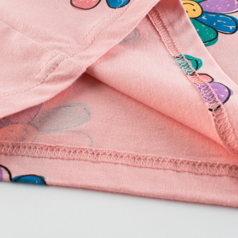 Baby girl wearing a pink sunflower print short sleeved t-shirt, perfect for summer days, showcasing a vibrant floral design.
